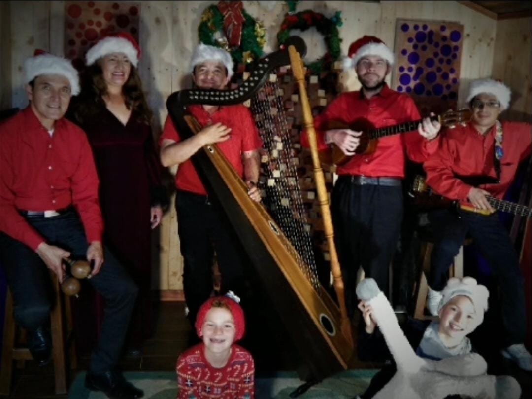El grupo tocando villancicos navideños con arpa, cuatro, maracas y bajo
